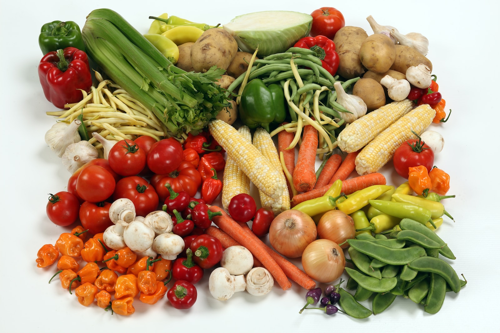 a pile of different types of vegetables on a white surface